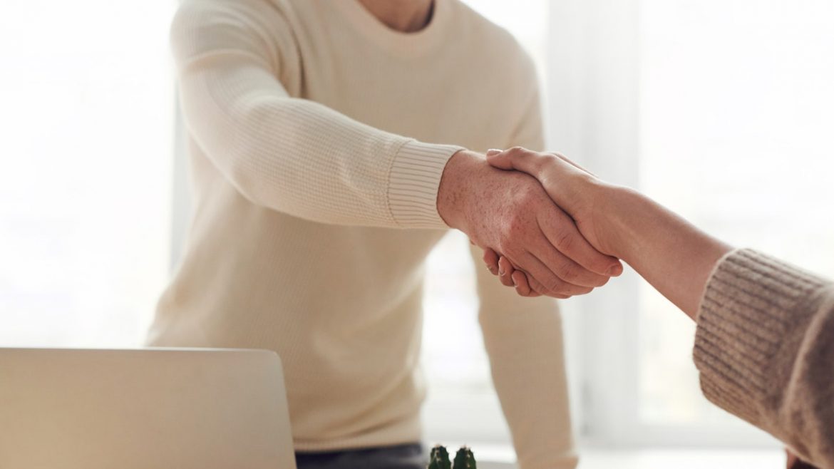 young man shaking hands with other person
